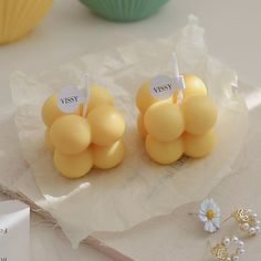 two yellow vases sitting on top of a table next to some pearls and other items