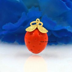 a close up of a small red object on a white surface with blue flowers in the background