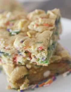 two pieces of cake with sprinkles on top of each other, sitting on a white plate