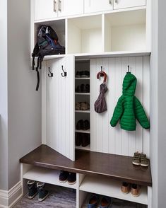 a coat rack with two coats hanging from it and shoes on the shelf next to it