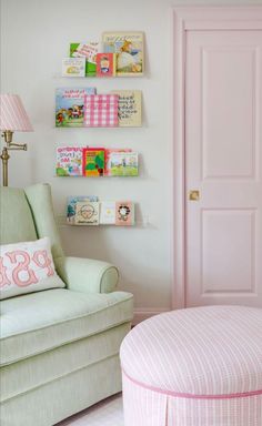 a baby's room with pink furniture and bookshelves on the wall above it