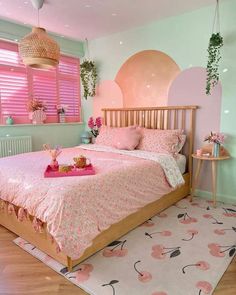 a bed with pink sheets and pillows in a bedroom next to a rug on the floor