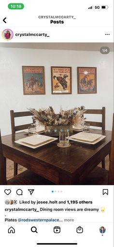 the table is set with place settings for two people to sit at, and there are pictures on the wall above it