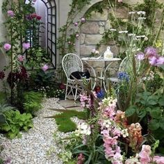 a garden with pink flowers and white chairs