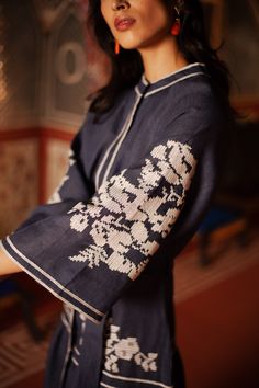 De Castro showcases a seamless and unique blend of traditional Indian craftsmanship, contemporary design, and the founder’s Colombian heritage. Every piece is handmade by artisans, using time-honored techniques and the finest cotton and silk fibers, resulting in exceptional quality, sustainability, and style. The Navy Swan Dress features front buttons, bell shaped raglan sleeves, Nehru collar, and tasseled belt. Product Details 100% linen. Hidden front buttons. Made in India. Care Instructions D