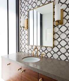 a bathroom sink with a mirror above it next to a wall mounted faucet