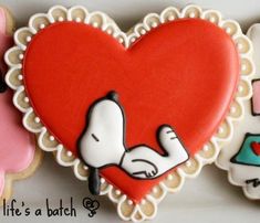 three decorated cookies in the shape of heart and snoopy with nurse's stethoscope