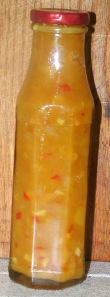 a glass jar filled with liquid sitting on top of a wooden table next to a wall