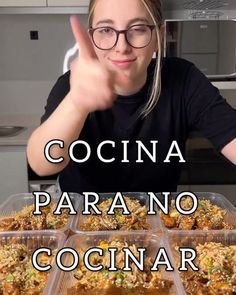 a woman giving the peace sign in front of several trays of food that have been placed on top of each other