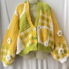 a yellow and green sweater with flowers on it