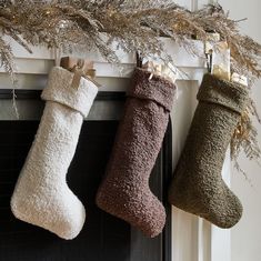 three christmas stockings hanging from a mantel