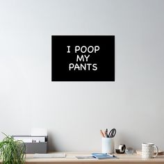 i poop my pants poster hanging on the wall above a desk with office supplies