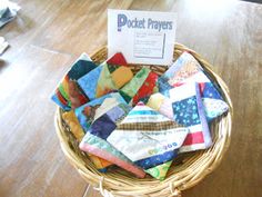 a basket filled with lots of different types of quilts on top of a wooden table