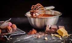 chocolates, nuts and other ingredients are on the counter next to a metal bowl