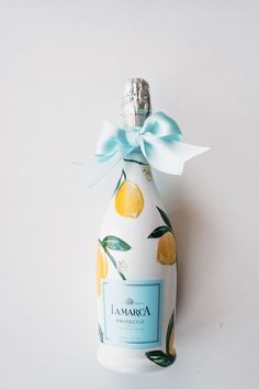 a bottle with a bow on it sitting next to a white wall and the words la marca written in spanish