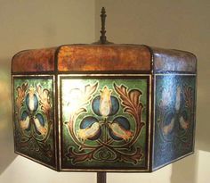 a lamp that is sitting on top of a wooden stand with an ornate design painted on it