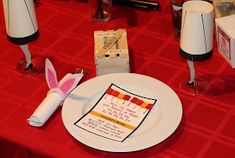 a red table topped with white plates and bunny ears