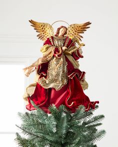 an angel statue on top of a christmas tree