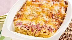 a casserole dish with ham and cheese in it on a wicker place mat