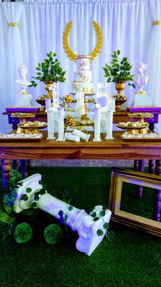 a table topped with lots of cakes and desserts on top of grass covered ground