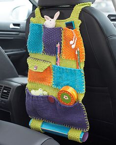 a car seat covered in a multi - colored crocheted organizer