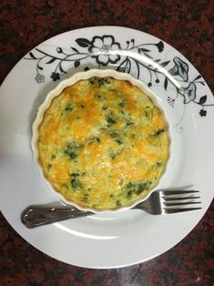 a white plate topped with a quiche next to a fork