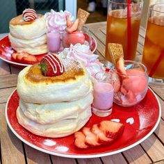 two red plates topped with desserts on top of a wooden table next to drinks