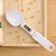 a white measuring spoon sitting on top of a wooden cutting board