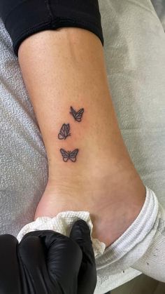 a woman's foot with three butterflies tattoo on her left side ribcage