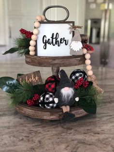 two tiered trays with christmas decorations and a sign that says gather on it