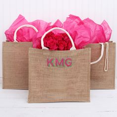 two jute bags with pink flowers in them