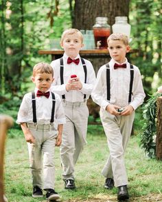 three young boys in white shirts and bow ties are walking through the grass with each other