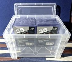 two clear storage boxes with 35 holders in them on top of a blue carpeted floor