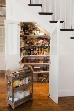 an open pantry under the stairs in a house