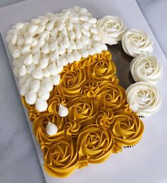 a cupcake with white frosting and roses in the shape of a heart on top