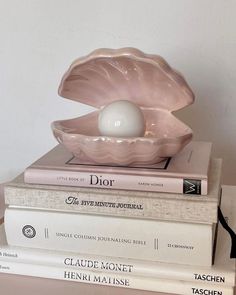 two books stacked on top of each other with an egg in the shell sitting on them