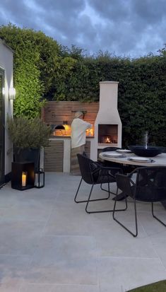 an outdoor dining area with fireplace and grill