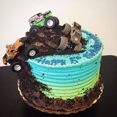 a birthday cake decorated with monster trucks and dirt