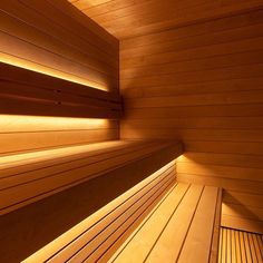 the inside of a wooden sauna with light shining on it's sides and floor