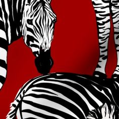 two zebras standing next to each other on a red background