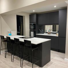 a kitchen with black cabinets and white counter tops