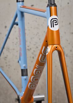 an orange and blue bicycle parked in front of a building