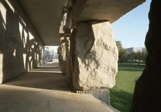 the walkway is lined with large rocks on both sides and grass in the back ground