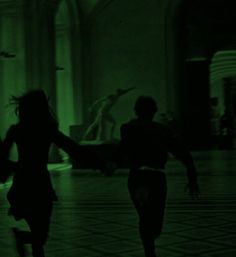 two people are running in the dark with their arms spread out and one person is holding his hand