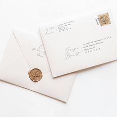 two envelopes with a wax stamp on the front, and a gold seal on the back