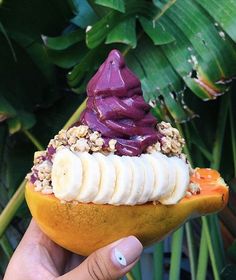 a person holding an orange with some kind of food on it