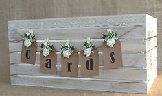 a wooden crate with some flowers on it and tags hanging from the handles that say cards