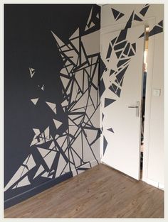 the wall is painted with black and white geometric designs on it's walls, along with wooden flooring