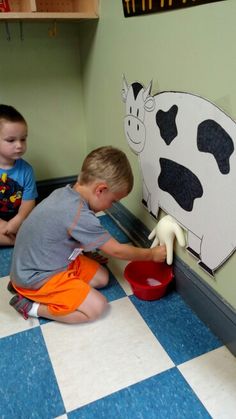 two young boys playing with toys in a playroom