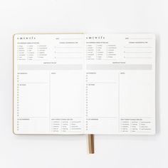 an open planner book on top of a white table